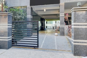 A gated entrance with a modern design, featuring a metal gate and stone pillars. - OYO VIBEHAUS (Hyderabad)