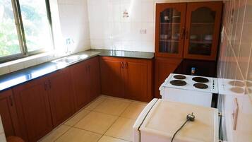 A kitchen with wooden cabinets, a white stove, and a window.