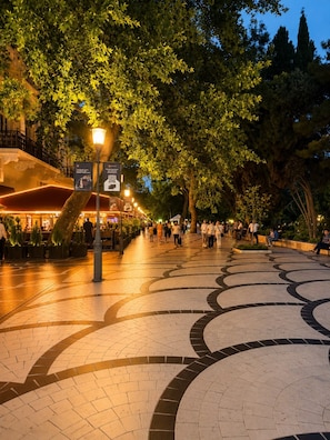 An outdoor pedestrian area with patterned paving, trees, and a street lamp. - La Casa Nizami Street (Baku)