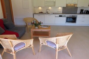 A modern kitchen with white cabinets, a built-in oven, and a coffee machine. - Holiday apartment with 1 bedroom (Steindorf)