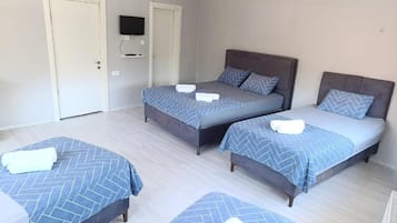 Una habitación de hotel con dos camas, un televisor y una puerta.