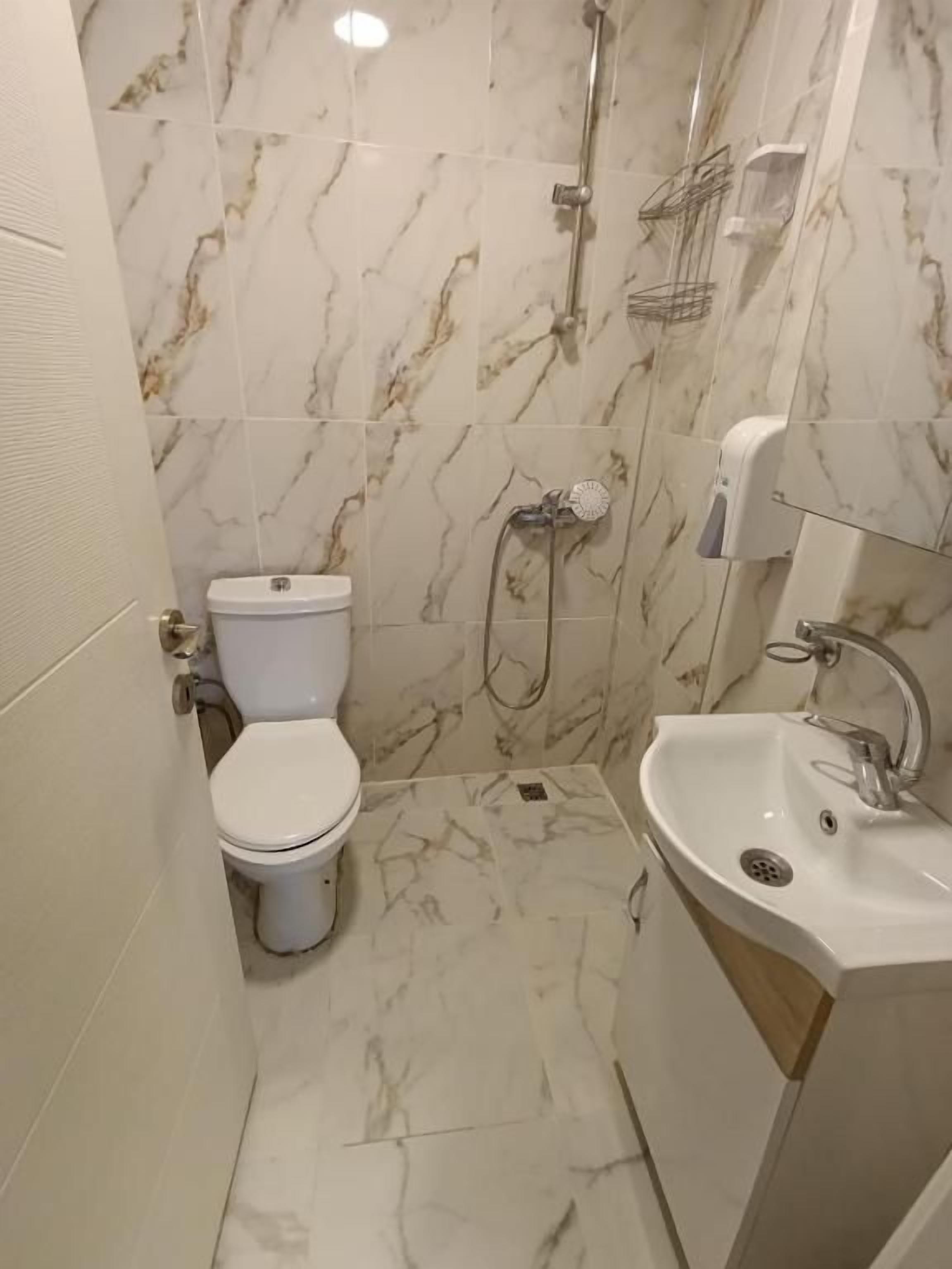 Un baño con inodoro, ducha y lavamanos.