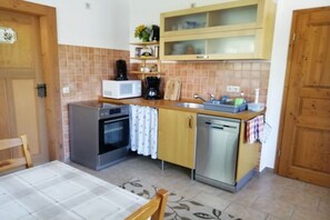 Een functionele keuken met een magnetron, oven en vaatwasser.