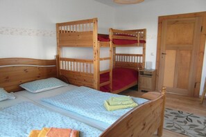 A room with a bunk bed, a desk, and a door. - Holiday apartment with 1 bedroom (Rathewalde)