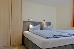 Ein Schlafzimmer mit einem Bett, einem Kleiderschrank und zwei Wandleuchten.