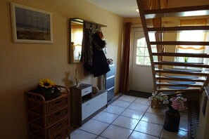 A room with a bed, a dresser, a mirror, a window with curtains, and a door. - Holiday home with 3 bedrooms (Drochtersen)