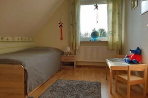 A bedroom with a bed, a nightstand, a desk, a globe, and a teddy bear. - Holiday home with 3 bedrooms (Drochtersen)