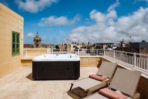A rooftop terrace with a hot tub, lounge chairs, and a view of the cityscape. - Casa Radiant (Rabat)