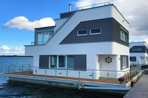 Un bateau moderne à plusieurs ponts, doté d’un pont supérieur, de fenêtres et d’un emblème représentant un volant.