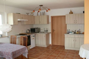 A compact kitchen with light wood cabinets, a microwave, a kettle, and a coffee maker. - Holiday apartment with 1 bedroom (Markkleeberg)