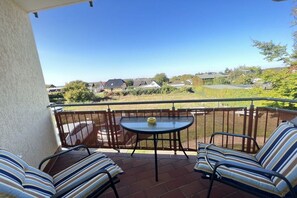 A balcony with a table and chairs, a view of a residential area, and a clear sky. - Holiday apartment with 1 bedroom (Koserow)