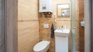 Ein Badezimmer mit Toilette, Waschbecken und Dusche.