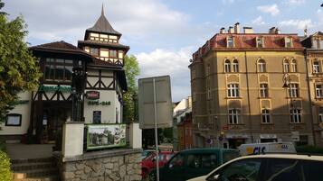 Un edificio tradicional con una torre, un café-bar y un restaurante llamado 'Panorama'.