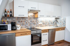 Eine moderne Küche mit weißen Schränken, einer gemusterten Spritzschutzwand und Edelstahlgeräten.