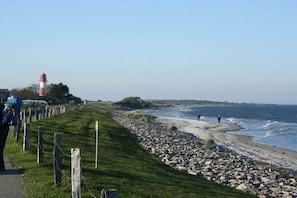 A coastal path with a lighthouse, rocky beach, and a grassy area. - Holiday apartment in Nieby with swimming pool (Nieby)