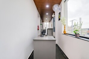 Un passadís amb una taula, un ordinador i un extintor.