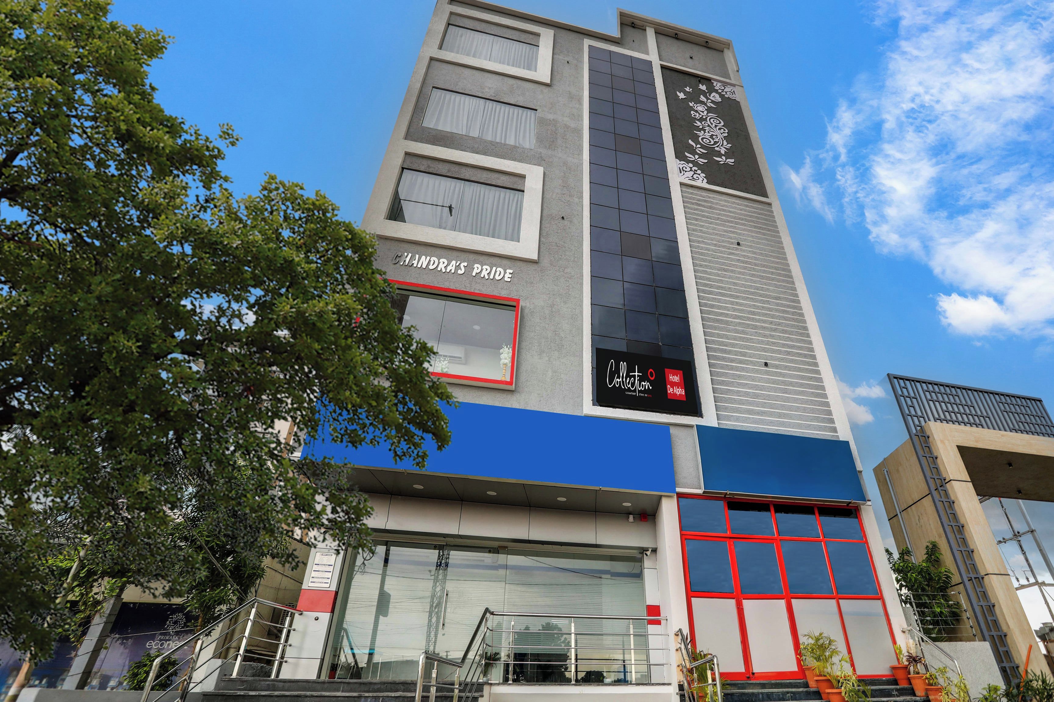 Un moderno edificio de hotel con un letrero destacado que dice 'Chandra's Pride' y un letrero que dice 'Collection Hotel De Alpha'.