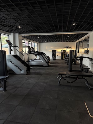 Ein Fitnessstudio mit Laufbändern, Kraftgeräten und einem Steiger.