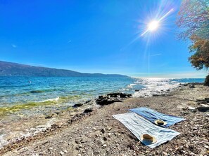A pebble beach with a clear view of the sea and distant hills. - D1MORA Nautilus - an incredible lakeside location (Lombardia)