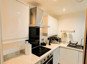 A compact kitchen with a stove, oven, and a sink. - Mathew Street - City 1 BDR apt sleeps 6 (Merseyside)