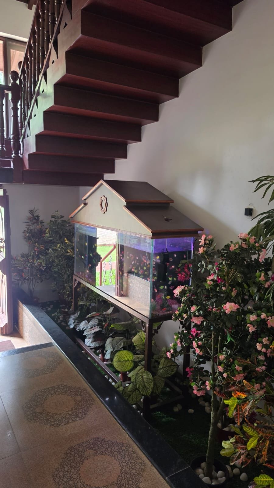Una escalera con un acuario y plantas artificiales.