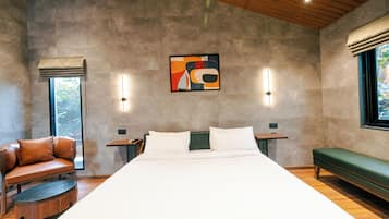 Un dormitorio moderno con una cama grande, un banco verde, una butaca de cuero y una obra de arte colgada en la pared.