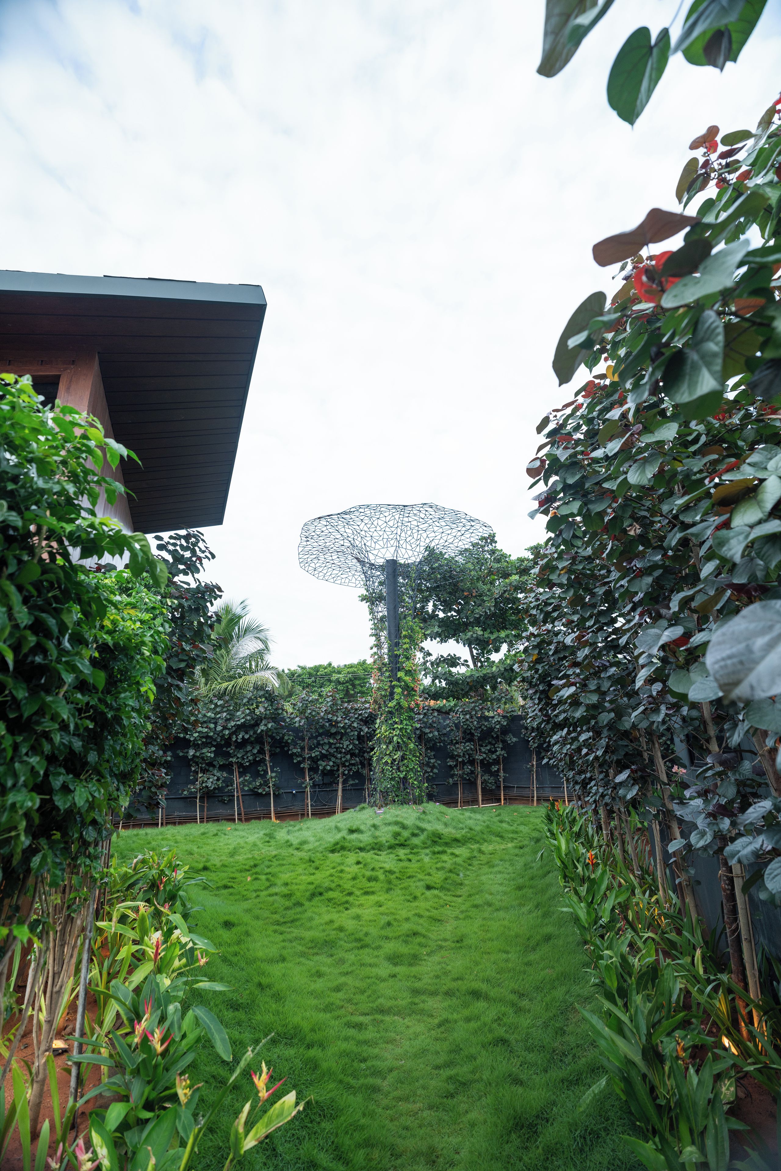 Un jardin bien entretenu, avec un chemin bien défini menant à un bâtiment au design moderne.