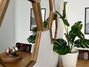 A room with a wooden dining table, a potted plant, and a framed mirror. - Mathew Street CITY - City 1 BDR apt sleeps 6 (Merseyside)
