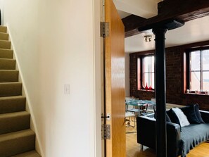 Eine Treppe führt zu einem Raum mit einem Essbereich, einem Sofa und einem Fenster mit Blick.