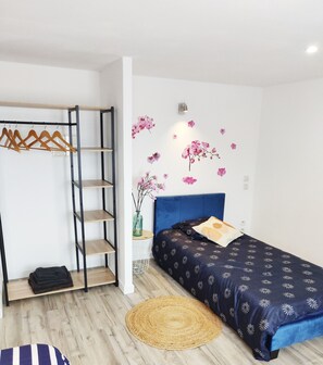 Ein Schlafzimmer mit einem Bett, einem Kleiderschrank, einer Wandablage und einem dekorativen Wandbild.
