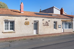 A stone building with a tiled roof, a plaque, and a sign indicating a historical site. - Bed and Breakfast 'Chambre 5' with Shared Terrace, Wi-Fi and Air Conditioning (Saint-Gervais)