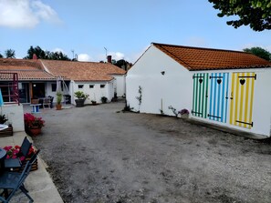 Un pati amb terra de grava, edificis blancs amb teulades vermelles i portes de colors.