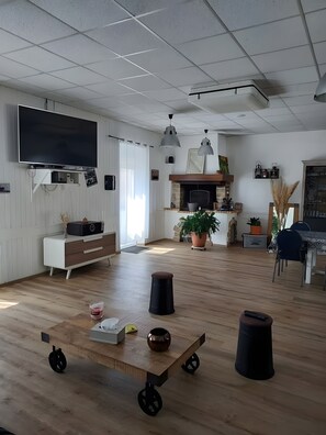 Un ampli saló amb televisió de pantalla plana, llar de foc i zona de menjador.