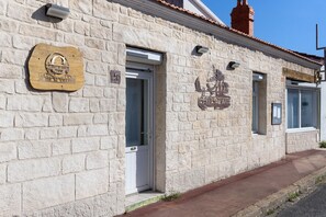 A stone building with a wooden signboard, a door, and a window. - Bed and Breakfast 'Chambre 2' with Shared Terrace, Wi-Fi and Air Conditioning (Saint-Gervais)