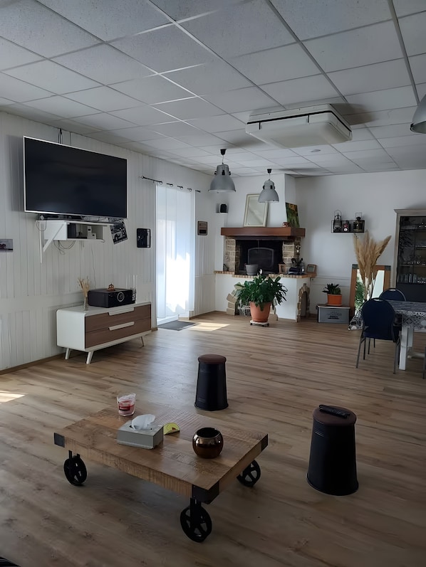Una sala de estar amplia con televisor de pantalla plana, chimenea y comedor.