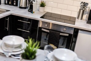A modern kitchen with stainless steel appliances, a sink, and a countertop with various items. - Jude`s Place 1 - 2 bedroomed apt/ 2 sofabeds (Merseyside)