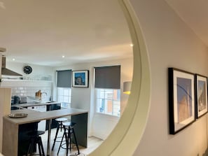 Eine moderne Küche mit Essbereich, einem großen Fenster und gerahmten Bildern an der Wand.