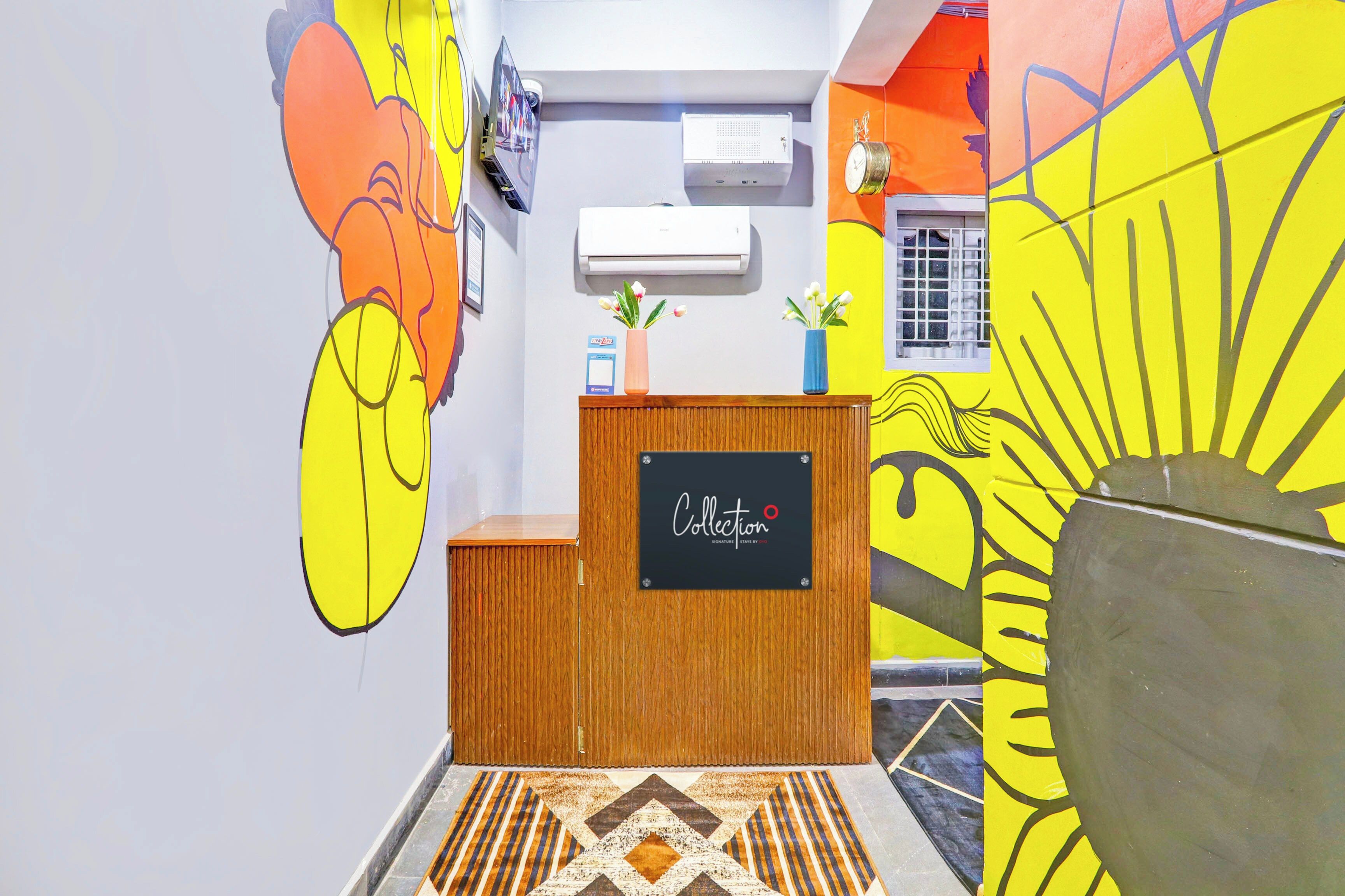 A reception desk with a chalkboard sign, a wall-mounted air conditioner, and a window with a grid pattern.