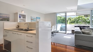 Eine moderne Küche mit integriertem Spülbecken, angrenzend an einen Essbereich mit Glastür zum Balkon.