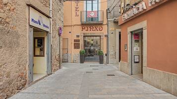 Una calle estrecha flanqueada por un hotel llamado 'HOTEL PIZZO' y una farmacia 'FARMACIA'.