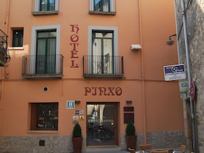 Un hotel con un letrero que dice 'HOTEL PJRXO' y una entrada visible con puerta de vidrio.