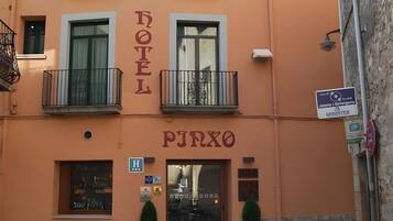 Un hotel con un letrero que dice 'HOTEL PJRXO' y una entrada visible con puerta de vidrio.