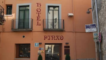 A hotel with a sign reading 'HOTEL PJRXO' and a visible entrance with a glass door.
