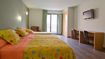 A hotel room with a large bed, a desk, and a TV.