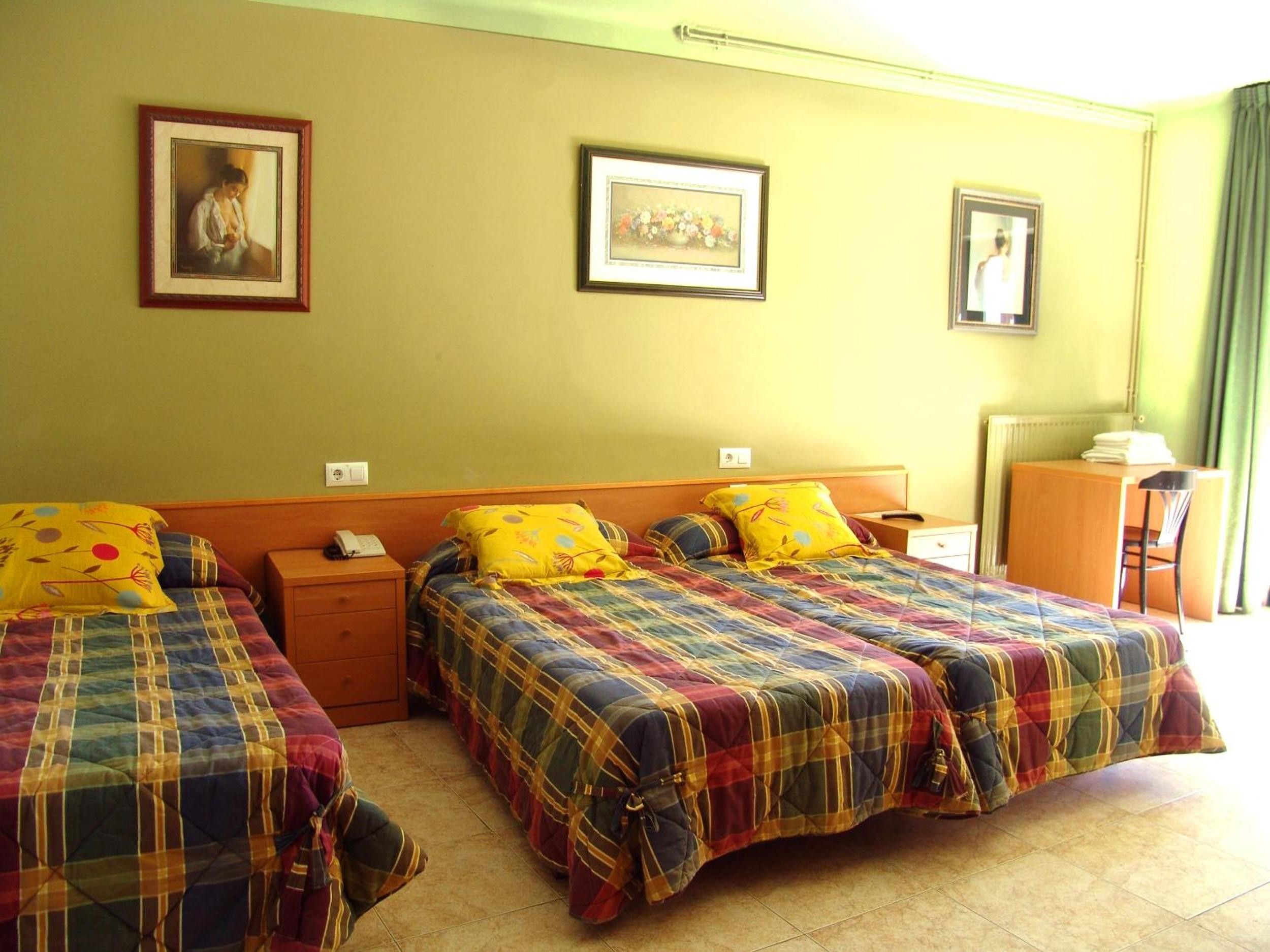 Una habitación de hotel con dos camas, un escritorio y una silla.