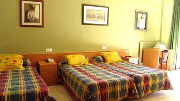 Una habitación de hotel con dos camas, un escritorio y una silla.