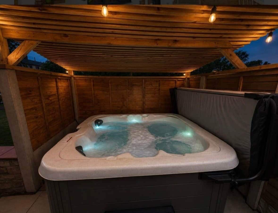 Un bain à remous sous une pergola en bois, avec vue sur le ciel.