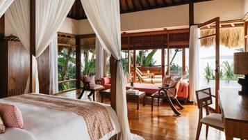 A room with a bed, a dining table, and a seating area with a view of the outdoors.