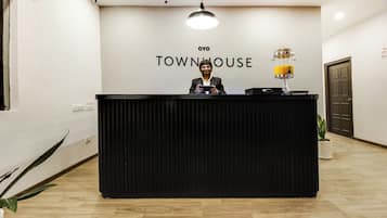 Un taulell de recepció amb un rètol que diu 'TOWNHOUSE' i una persona al darrere.
