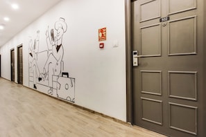 A hallway with a wall mural, a fire alarm pull station, and a door labeled '502'. - Townhouse Meridian Regency (Hyderabad)